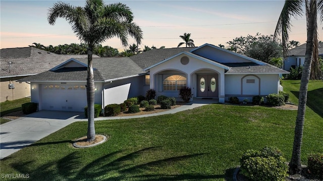 single story home with a garage and a lawn