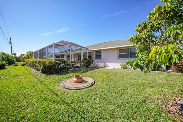 back of property with glass enclosure and a lawn