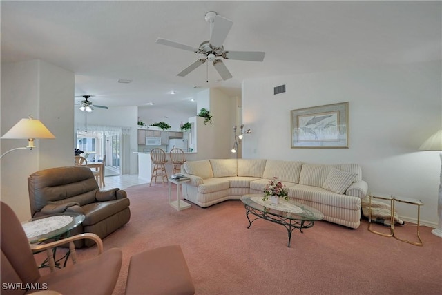 living room with lofted ceiling, ceiling fan, and carpet flooring