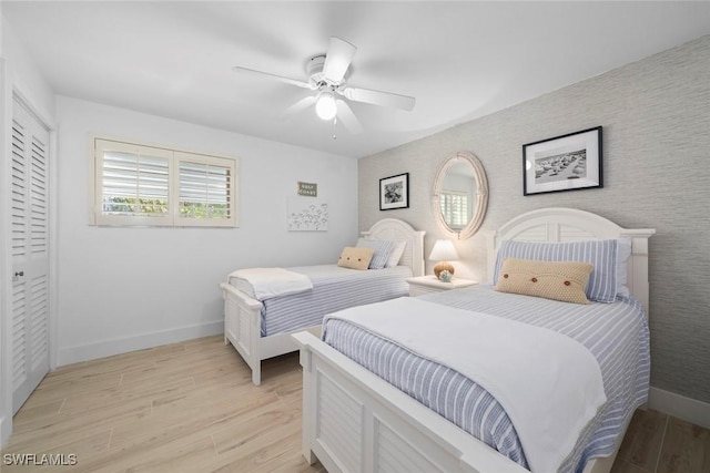 bedroom with ceiling fan, light hardwood / wood-style floors, and a closet