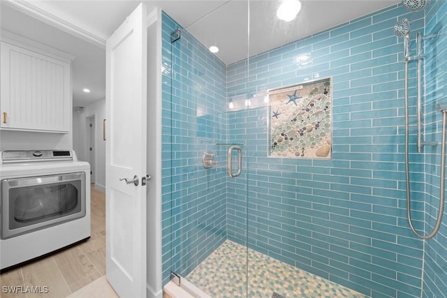 bathroom featuring hardwood / wood-style flooring, washer / dryer, and walk in shower