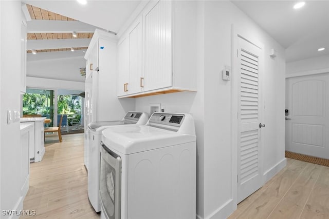 laundry room featuring wood ceiling, washer and clothes dryer, light hardwood / wood-style floors, and cabinets