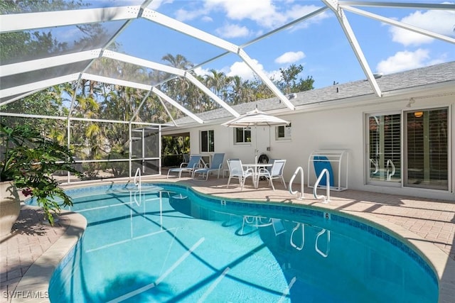 view of swimming pool featuring a patio and glass enclosure