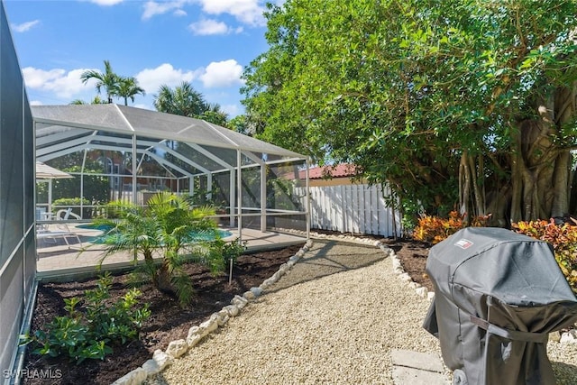 view of yard featuring glass enclosure and a patio area