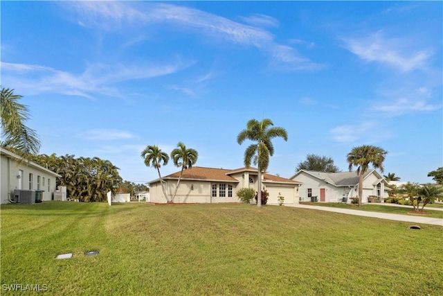 view of front of house featuring a garage, a front lawn, and central air condition unit