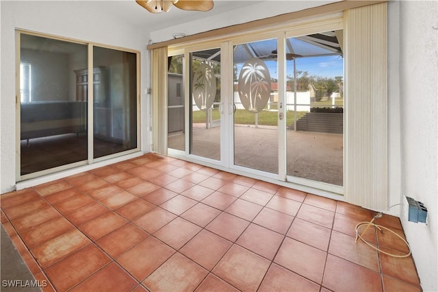 unfurnished sunroom featuring ceiling fan