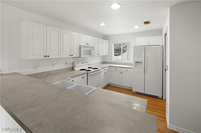 kitchen featuring white cabinetry, sink, white appliances, and light hardwood / wood-style flooring