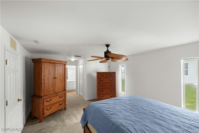 bedroom featuring ceiling fan, ensuite bathroom, and light carpet