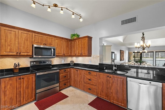 kitchen featuring sink, tasteful backsplash, light tile patterned floors, dark stone counters, and stainless steel appliances