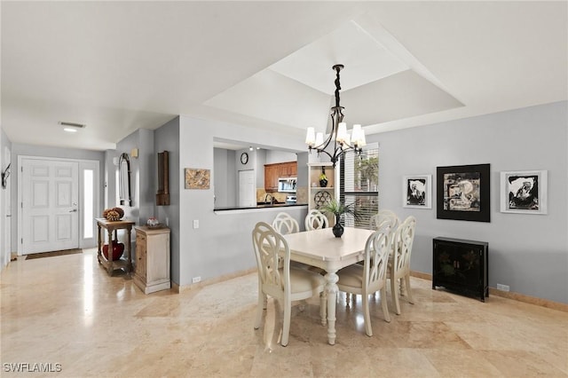 dining room with a raised ceiling and an inviting chandelier