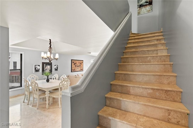 staircase with an inviting chandelier