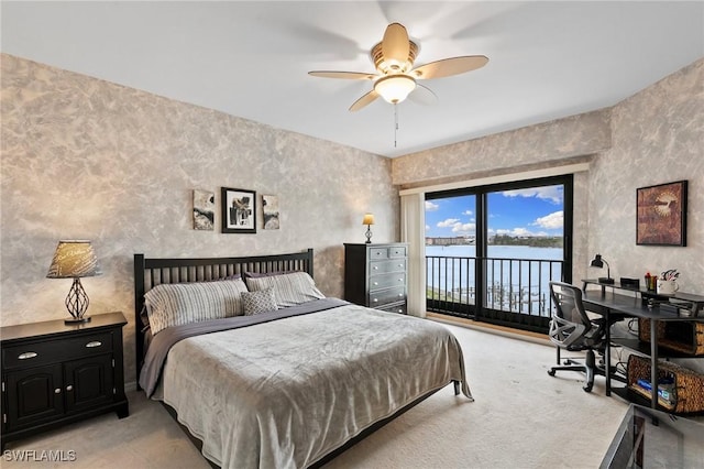 bedroom with a water view, access to outside, light carpet, and ceiling fan