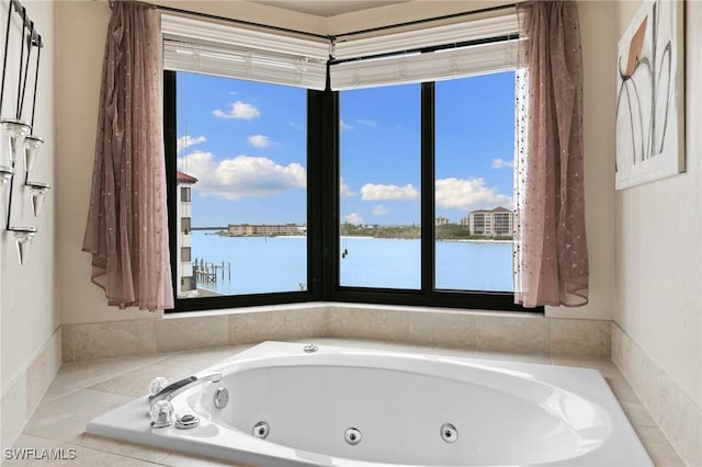 bathroom featuring a water view and a relaxing tiled tub