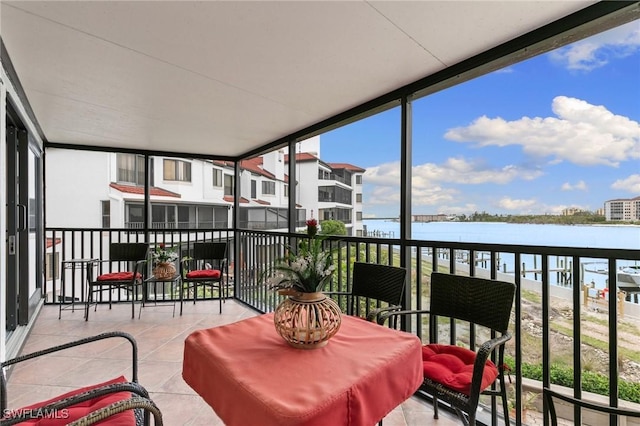 sunroom featuring a water view