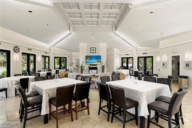 dining room with french doors, light tile patterned flooring, and vaulted ceiling