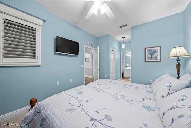 carpeted bedroom featuring a closet, ceiling fan, and ensuite bathroom