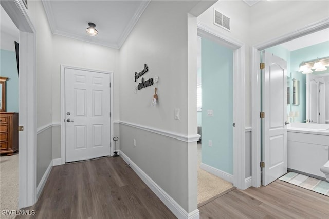 hallway featuring ornamental molding and wood-type flooring