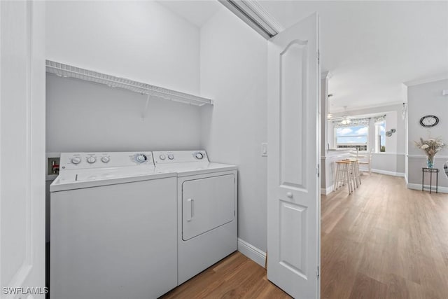 laundry room with washer and clothes dryer and light hardwood / wood-style floors