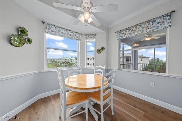 dining area with hardwood / wood-style flooring, ornamental molding, and a wealth of natural light