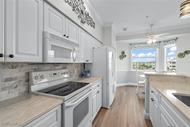 kitchen with tasteful backsplash, white cabinets, ornamental molding, white appliances, and light hardwood / wood-style flooring