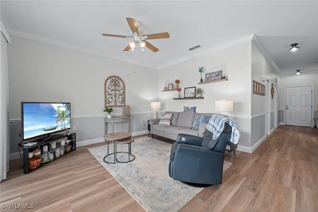 living room with ceiling fan, ornamental molding, and light hardwood / wood-style floors