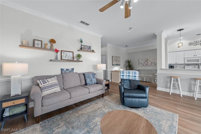 living room featuring crown molding, ceiling fan, and light hardwood / wood-style flooring