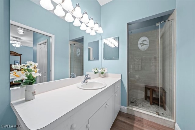 bathroom featuring ceiling fan, vanity, a shower with door, and hardwood / wood-style floors