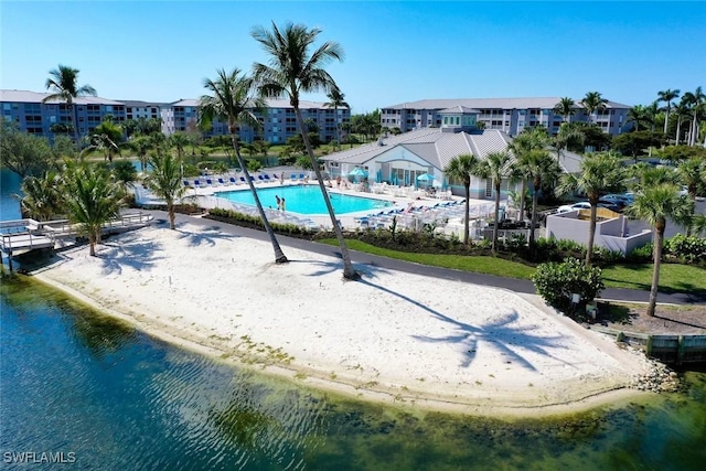 view of pool with a water view, a beach view, and a patio area