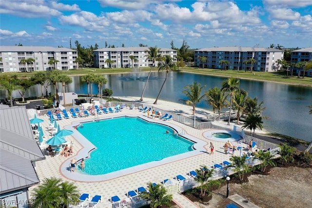 view of swimming pool featuring a water view, a community hot tub, and a patio