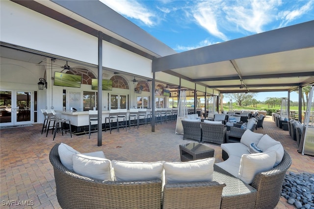 view of patio / terrace featuring a bar, an outdoor living space, and french doors