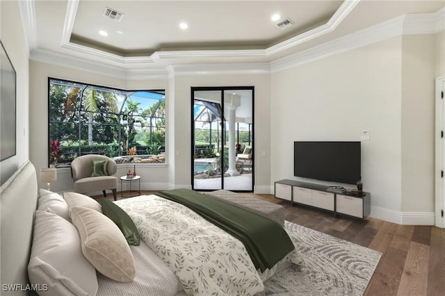 bedroom featuring dark wood-type flooring, ornamental molding, a tray ceiling, and access to exterior