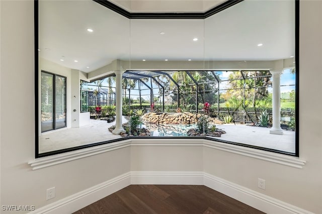 interior space with dark hardwood / wood-style floors, a healthy amount of sunlight, and ornate columns