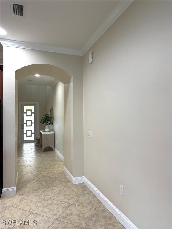 corridor featuring crown molding and light tile patterned floors