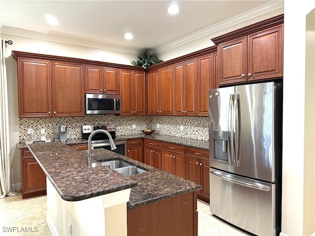 kitchen featuring dark stone countertops, appliances with stainless steel finishes, a center island with sink, and backsplash