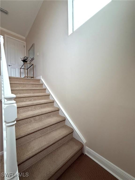 stairs featuring crown molding