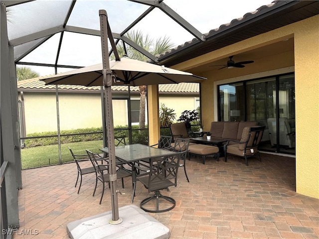 view of patio / terrace featuring ceiling fan, an outdoor hangout area, and glass enclosure