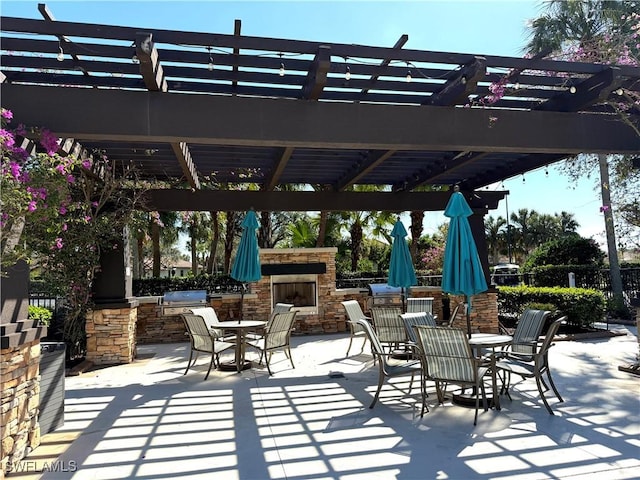 view of patio featuring a pergola and an outdoor stone fireplace