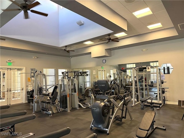 workout area with french doors, ceiling fan, a paneled ceiling, and a high ceiling