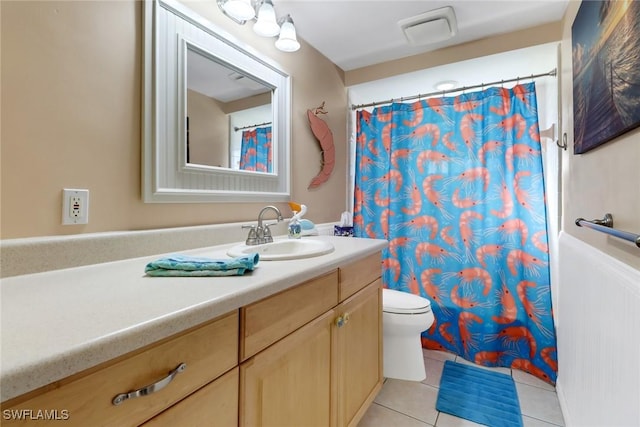 bathroom featuring tile patterned flooring, vanity, and toilet