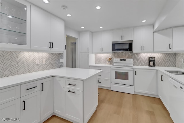 kitchen featuring white cabinets, white appliances, and light hardwood / wood-style floors