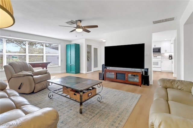 living room featuring light hardwood / wood-style flooring and ceiling fan