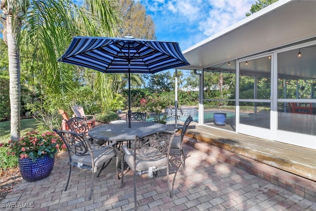 view of patio / terrace featuring a pool side deck and a sunroom