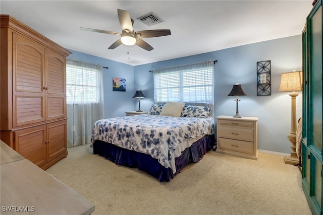 bedroom featuring multiple windows, light colored carpet, and ceiling fan