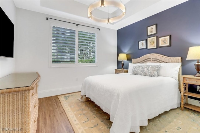 bedroom featuring a tray ceiling and hardwood / wood-style flooring