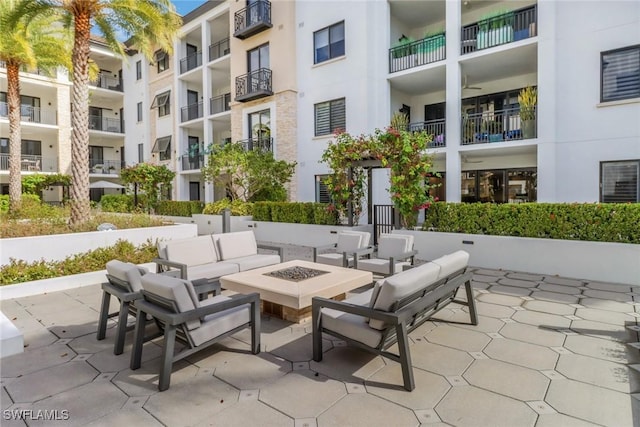 view of property's community featuring a patio and a fire pit