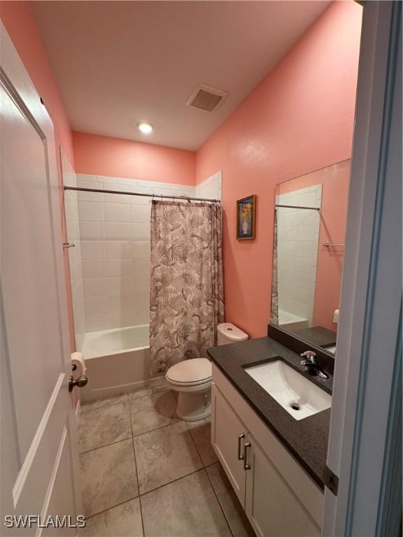 full bathroom with tile patterned flooring, vanity, shower / bath combo, and toilet