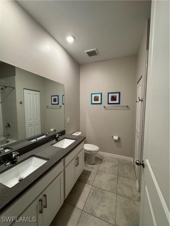 full bathroom with bathtub / shower combination, tile patterned floors, toilet, and vanity