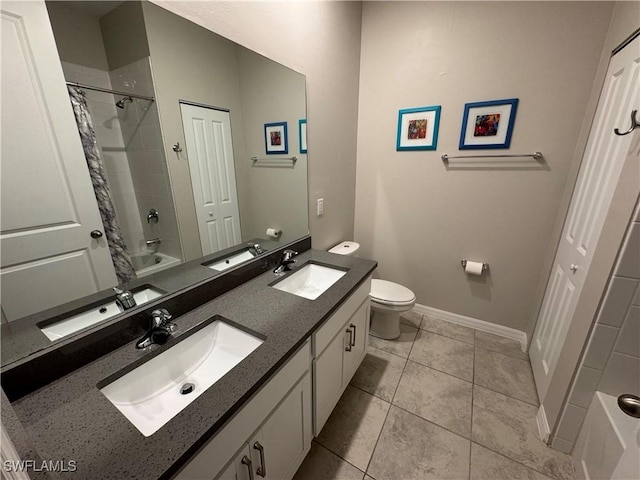 full bathroom with tile patterned flooring, vanity, tiled shower / bath, and toilet