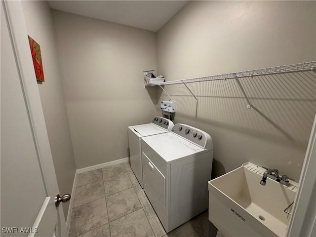 laundry room with washing machine and clothes dryer, sink, and light tile patterned floors