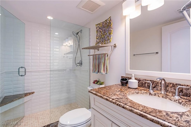 full bath with toilet, a stall shower, vanity, and visible vents